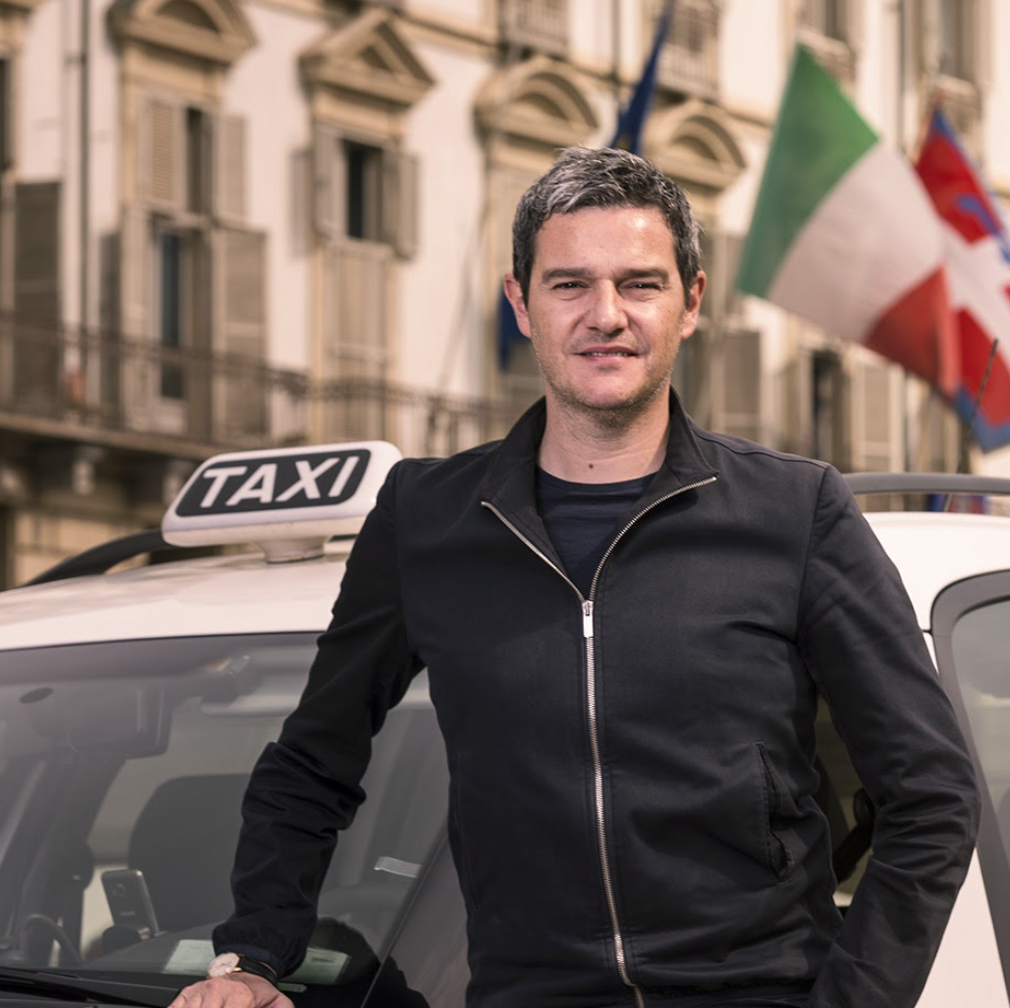 Foto di un uomo davanti ad un taxi